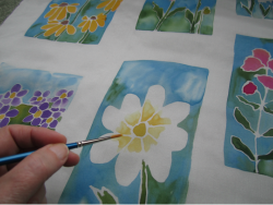 Artist painting a flower on silk